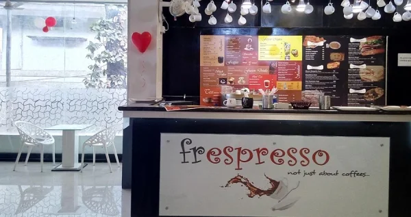 The serving counter of a cafe with its menu display in the backdrop