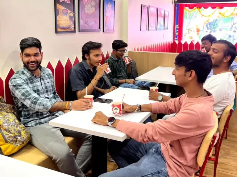 A group of friends guys drinking cold coffee during a party at a fast food place