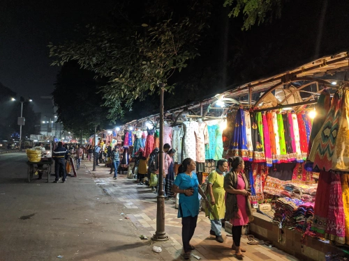 Women shopping at Law Garden Market during night.