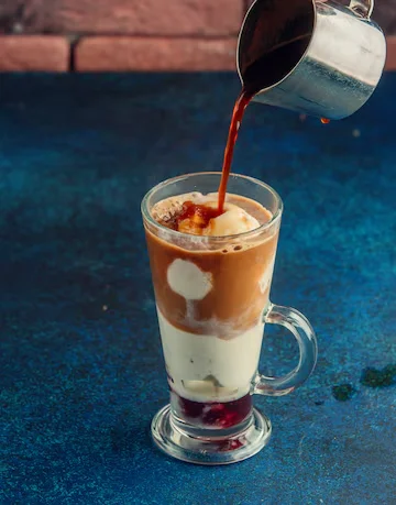 A glass of fusion coffee topped with whipped cream.