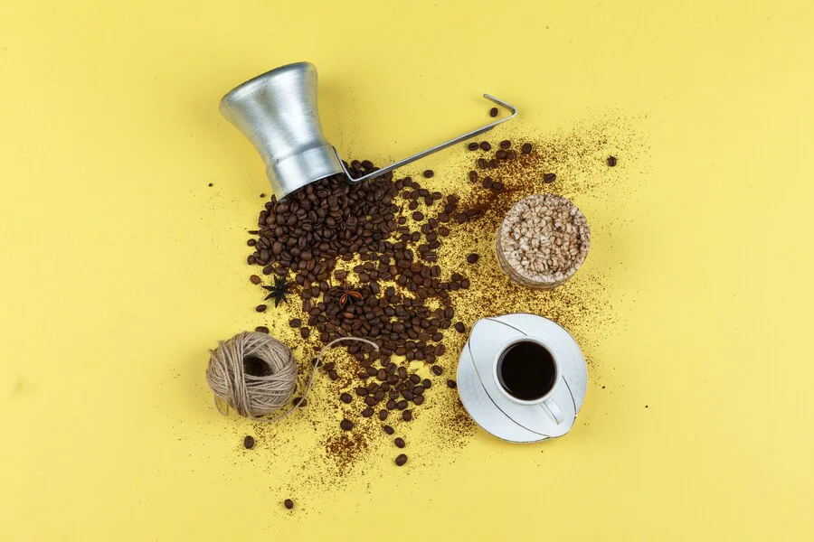 Cup of coffee, rice cakes, ropes and coffee beans on a yellow background