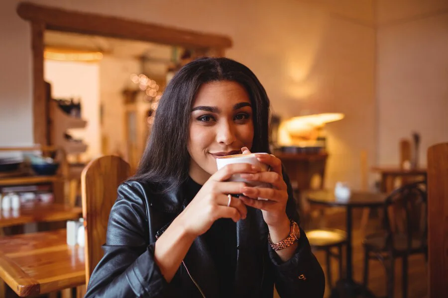 An Indian woman sipping coffee