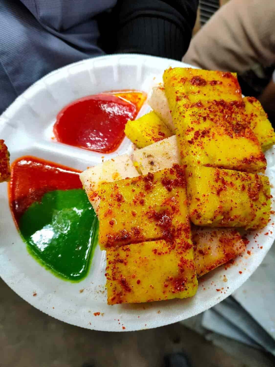 An image of live dhokla served on a plate with chutney.